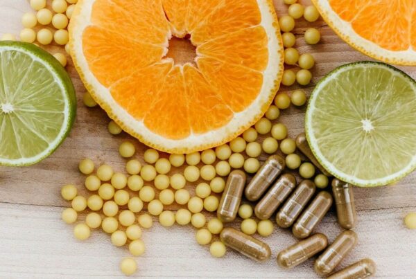 Creatine, calcium, vitamin D3, and magnesium supplements on a physical therapy clinic counter with exercise equipment and adults doing strength and balance training